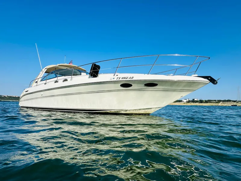 Slide: The Image of 2002 Sea Ray 410 Express Cruiser on calm water under clear blue sky. - 3