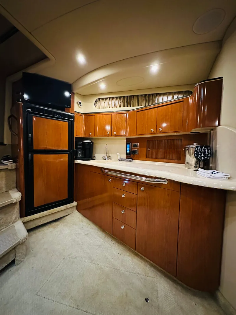 Slide: The Image of 2002 Sea Ray 410 Express Cruiser kitchen with wood cabinetry and modern appliances. - 32