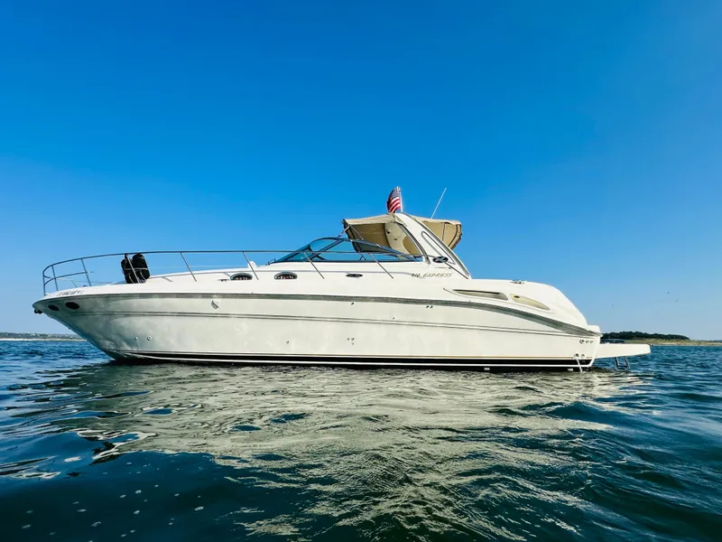 Slide: The Image of 2002 Sea Ray 410 Express Cruiser on calm water under clear blue sky. - 7