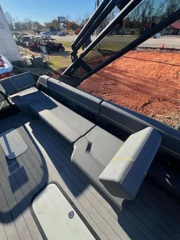 Slide: The Image of 2023 Manitou EXPLORE 22 boat interior with gray seating and deck, outdoor setting. - 7