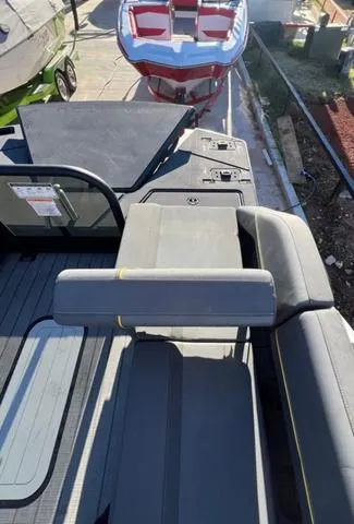 Slide: The Image of 2023 Manitou EXPLORE 22 boat interior with seating and deck view. - 9