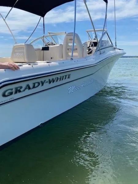 Slide: The Image of 2022 Grady-White Freedom 215 boat on calm water under blue sky. - 16