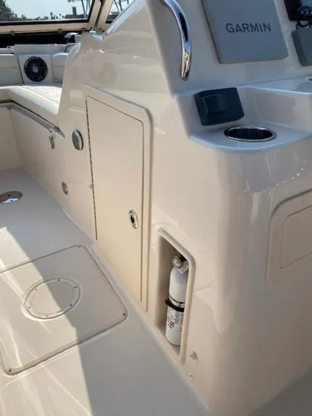 Slide: The Image of 2022 Grady-White Freedom 215 boat interior with Garmin equipment and storage compartments. - 6