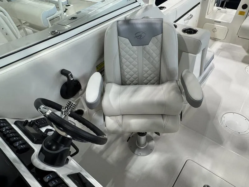 Slide: The Image of 2025 Sailfish 245 DC boat interior with captain's chair and steering wheel. - 11