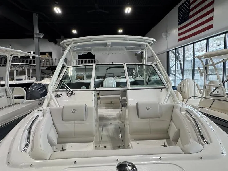 Slide: The Image of 2025 Sailfish 245 DC boat interior with seating, displayed indoors near an American flag. - 4