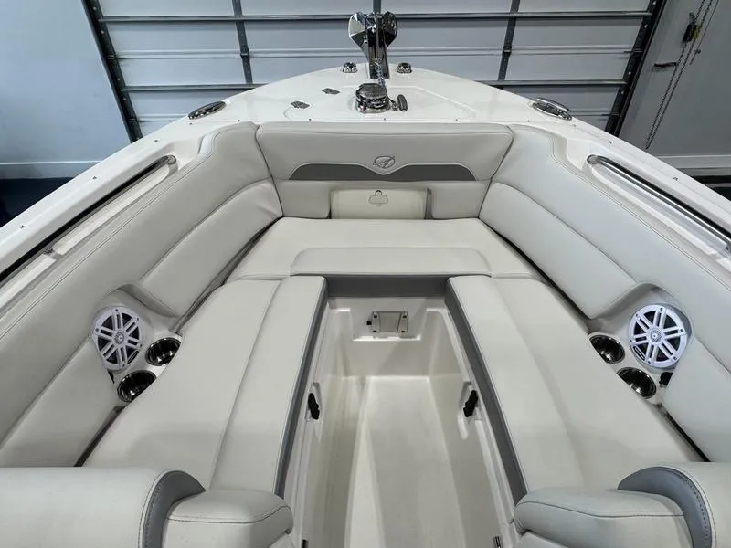 Slide: The Image of 2025 Sailfish 245 DC boat interior with white cushioned seating and built-in speakers. - 7