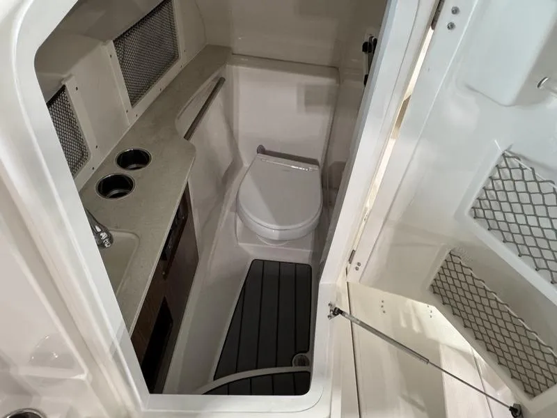 Slide: The Image of 2025 Sailfish 245 DC boat interior with compact bathroom and modern amenities. - 8