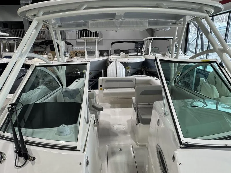 Slide: The Image of 2025 Sailfish 245 DC boat interior with seating and windshield, displayed in a showroom. - 9