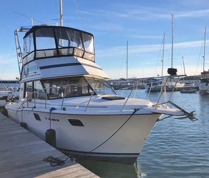 The Image of 1988 Carver 3227 yacht docked at marina, clear sky, calm water. - 1