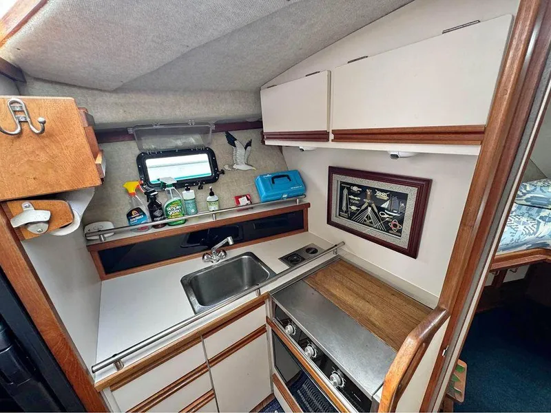 Slide: The Image of 1988 Carver 3227 boat kitchen with sink, stove, and storage cabinets. - 6