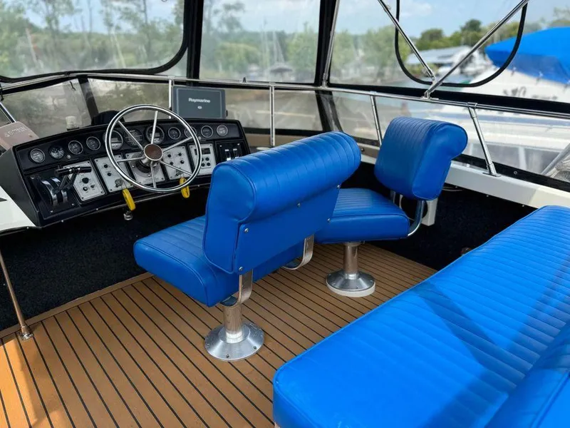 Slide: The Image of 1988 Carver 3227 boat interior with blue seating and wooden flooring. - 7