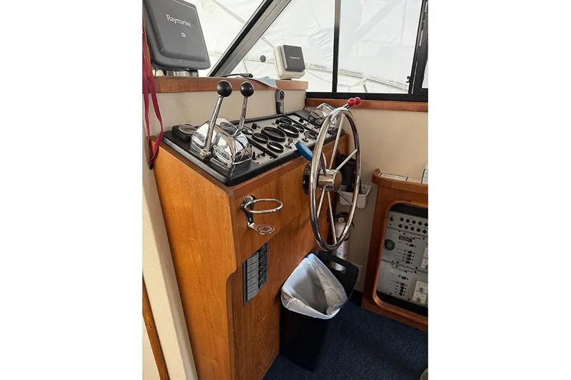 Slide: The Image of 1988 Carver 3227 Convertible boat helm with steering wheel and controls. - 11