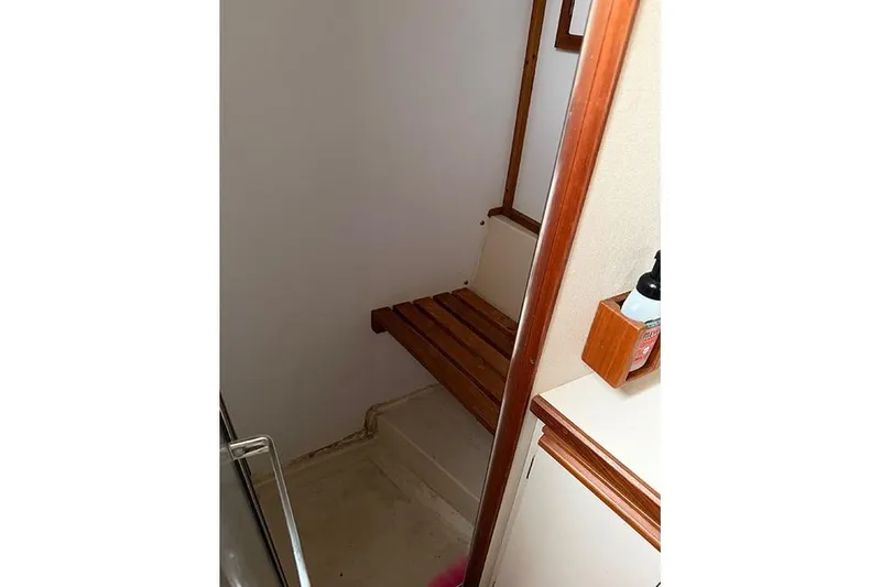 Slide: The Image of 1988 Carver 3227 Convertible interior with wooden bench and storage shelf. - 14