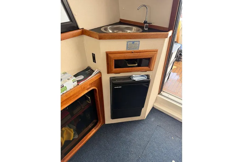 Slide: The Image of 1988 Carver 3227 Convertible interior with sink, mini-fridge, and wooden cabinetry. - 19