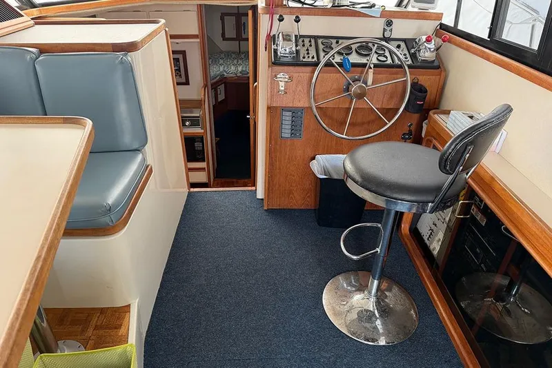 Slide: The Image of 1988 Carver 3227 Convertible boat interior with helm, seating, and cabin entrance. - 21