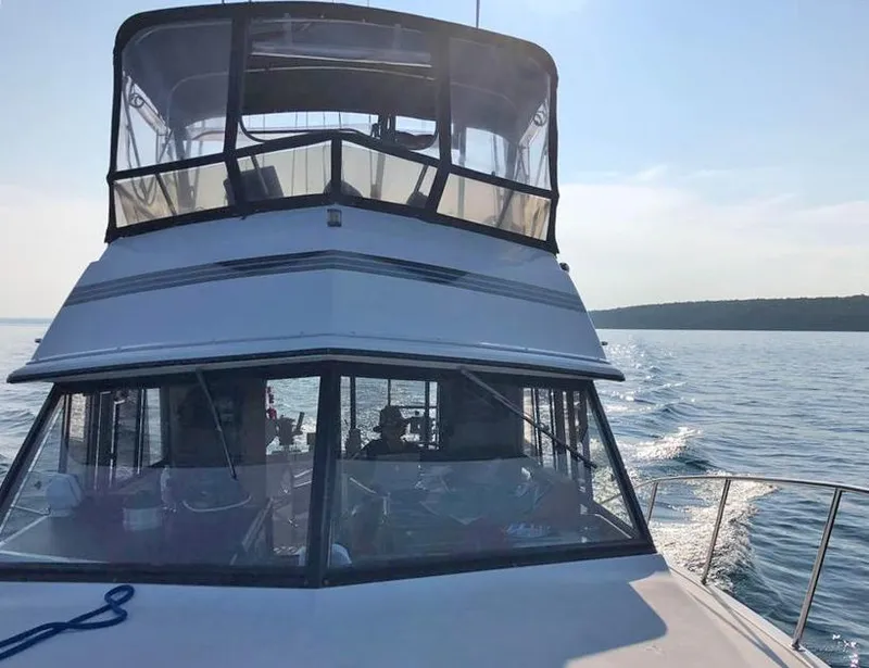 Slide: The Image of 1988 Carver 3227 boat cruising on open water under clear skies. - 4