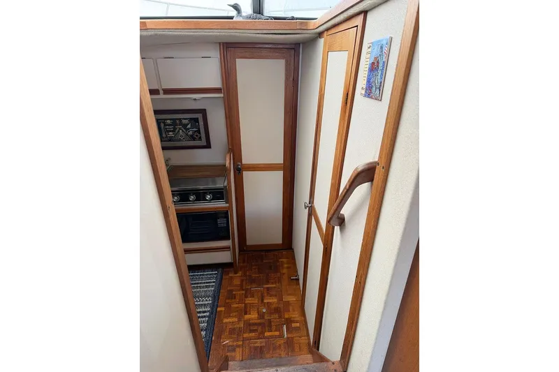 Slide: The Image of 1988 Carver 3227 Convertible interior with wood accents and compact kitchen area. - 9