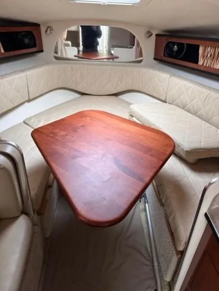 Slide: The Image of Interior of 2007 Sea Ray 280 Sundancer with wooden table and cushioned seating. - 11