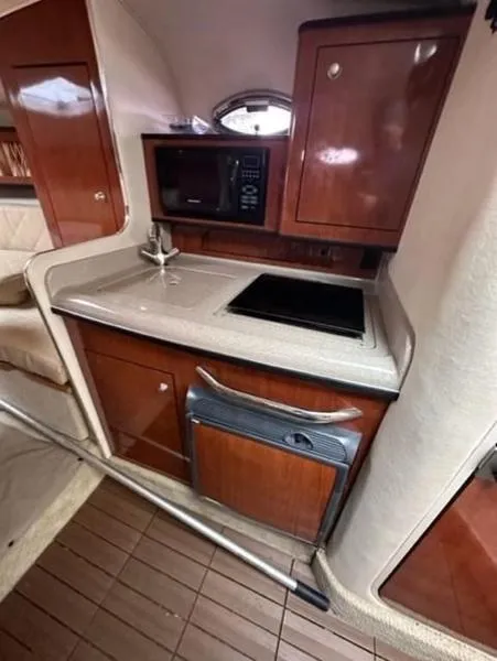 Slide: The Image of 2007 Sea Ray 280 Sundancer cabin kitchen with wood cabinets and modern appliances. - 3