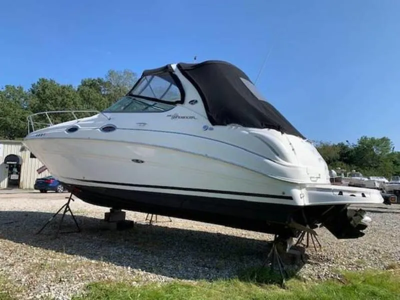 Slide: The Image of 2007 Sea Ray 280 Sundancer boat on stands, black canopy, outdoors. - 8