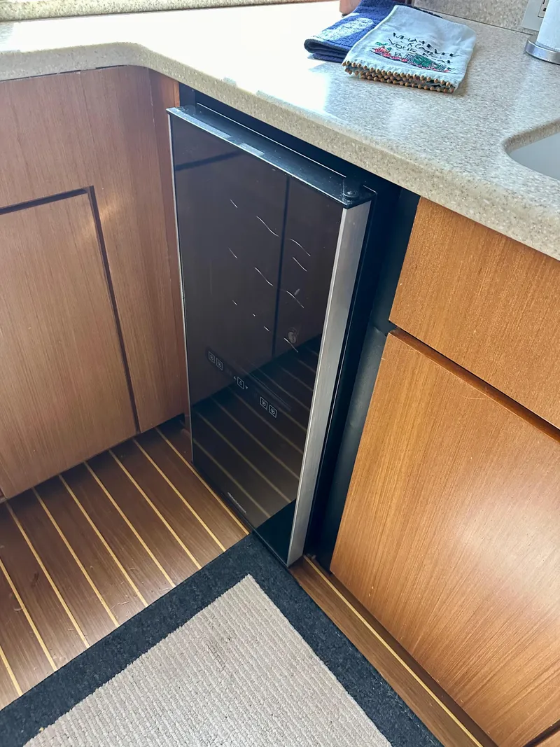 Slide: The Image of Compact fridge in 1997 Ocean Yachts 60 Super Sport kitchen with wooden cabinetry. - 10