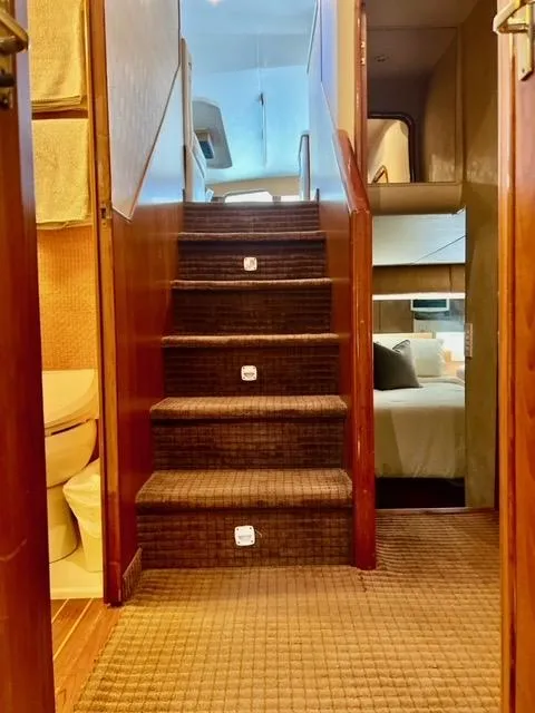 Slide: The Image of Interior view of 1997 Ocean Yachts 60 Super Sport, featuring carpeted stairs and cozy cabin. - 12