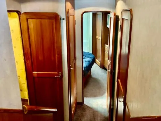 Slide: The Image of Interior hallway of 1997 Ocean Yachts 60 Super Sport with wooden doors and carpeted floor. - 18