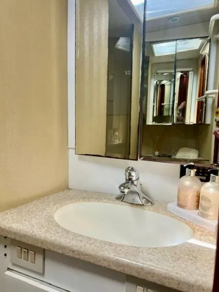 Slide: The Image of Bathroom vanity in 1997 Ocean Yachts 60 Super Sport, featuring a sink and mirrored cabinet. - 21