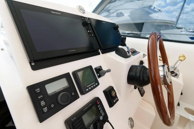 Slide: The Image of 2006 Tiara Yachts 4300 Sovran helm with navigation equipment and wooden steering wheel. - 10