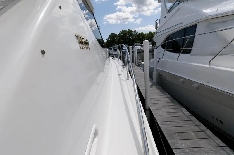 Slide: The Image of 2006 Tiara Yachts 4300 Sovran docked beside another boat under a partly cloudy sky. - 13