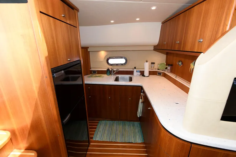 Slide: The Image of Luxurious 2006 Tiara Yachts 4300 Sovran kitchen with wood cabinetry and modern appliances. - 16