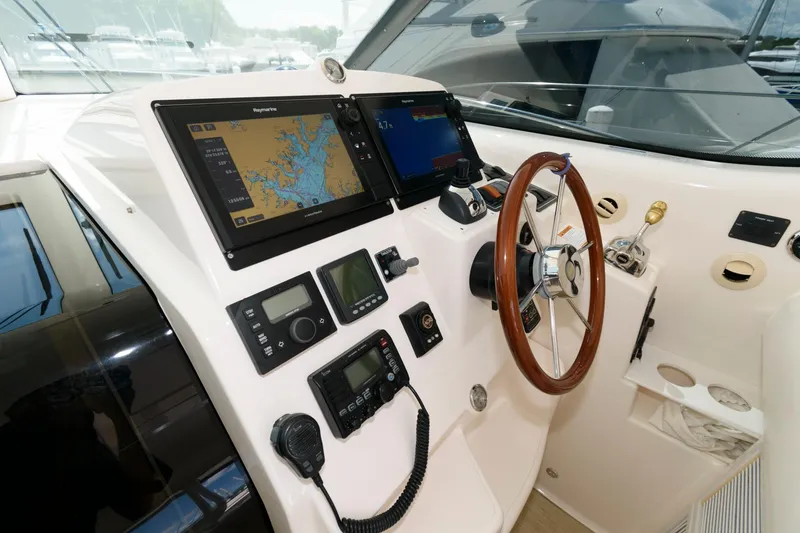 Slide: The Image of 2006 Tiara Yachts 4300 Sovran helm with navigation equipment and wooden steering wheel. - 8