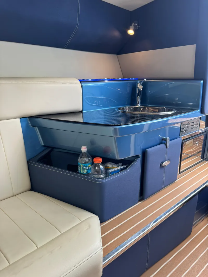 Slide: The Image of 2013 Nor-Tech 420 Monte Carlo interior with kitchenette and seating area. - 16