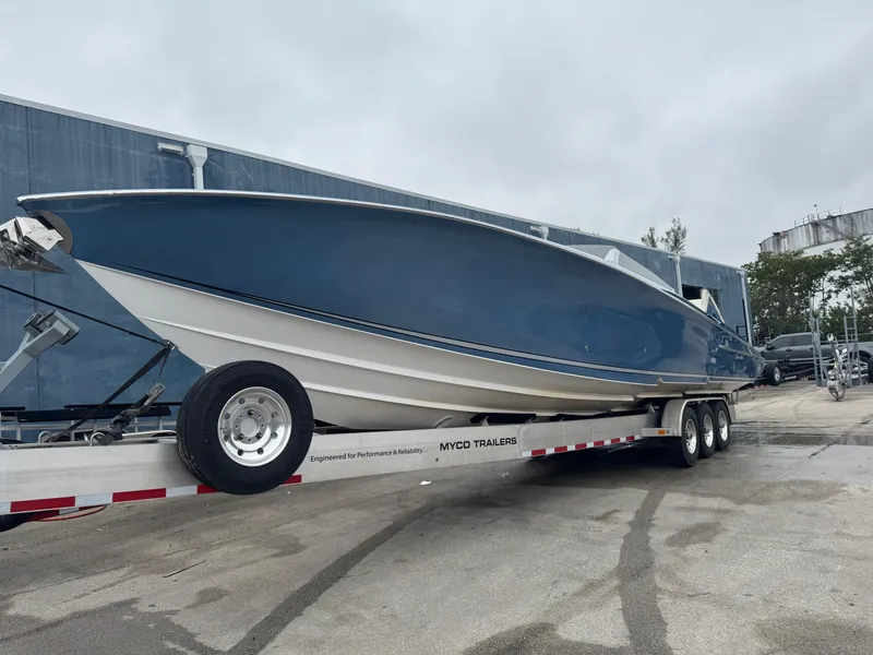 Slide: The Image of 2013 Nor-Tech 420 Monte Carlo boat on trailer, blue hull, parked outdoors. - 27