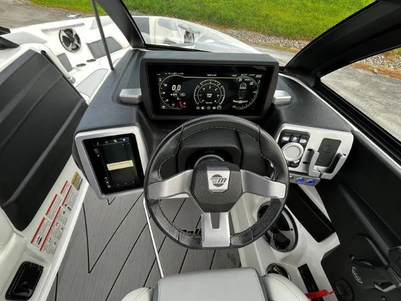 Slide: The Image of 2020 Malibu 25 LSV boat dashboard with modern steering and digital display. - 26