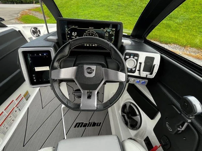 Slide: The Image of 2020 Malibu 25 LSV boat dashboard with modern steering and digital display. - 27