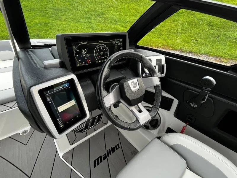 Slide: The Image of 2020 Malibu 25 LSV boat dashboard with modern steering and digital displays. - 28