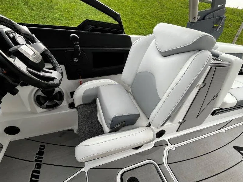 Slide: The Image of 2020 Malibu 25 LSV boat interior with white captain's seat and steering wheel. - 29
