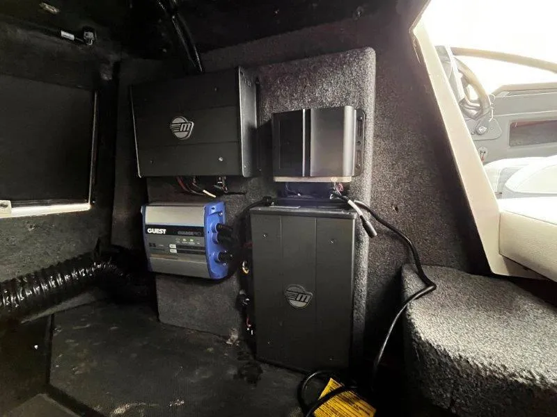 Slide: The Image of 2020 Malibu 25 LSV interior electronics setup with audio and power components. - 37