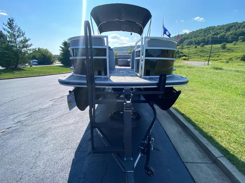Slide: The Image of 2024 Ranger Reata 223C pontoon boat on trailer, sunny day, scenic background. - 2