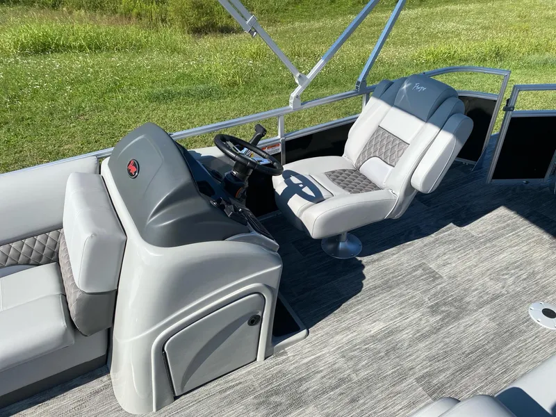 Slide: The Image of 2024 Ranger Reata 223C boat interior with gray seating and steering console. - 7