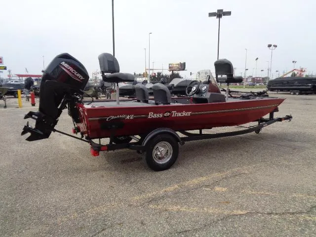 Slide: The Image of 2024 Tracker Bass Tracker Classic XL boat with Mercury outboard motor in parking lot. - 4