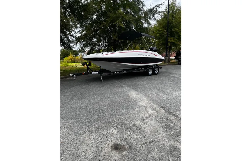 The Image of 2024 Tahoe 2150 boat on trailer, parked outdoors under trees. - 0
