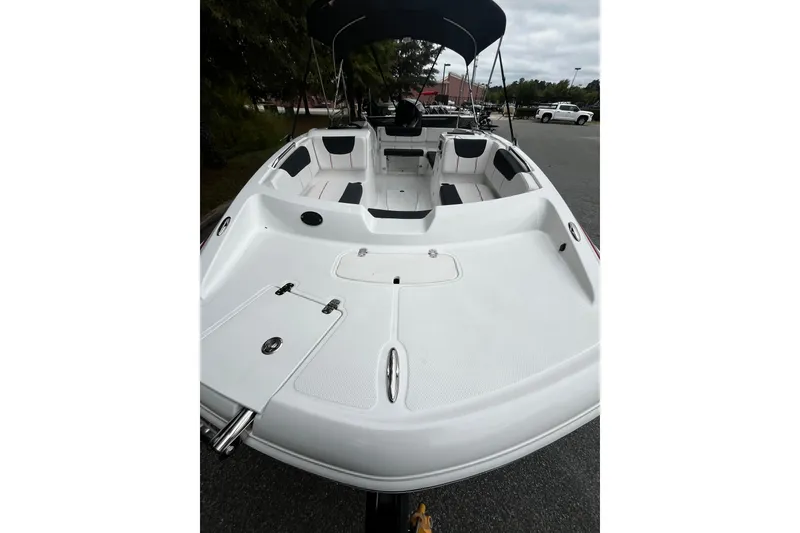 Slide: The Image of 2024 Tahoe 2150 boat interior with seating and canopy, parked outdoors. - 6