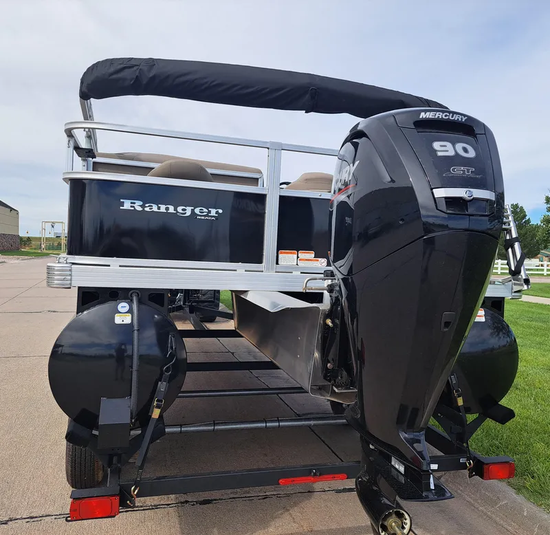 Slide: The Image of 2024 Ranger Reata 200F boat with Mercury 90 outboard motor, parked on a trailer. - 2