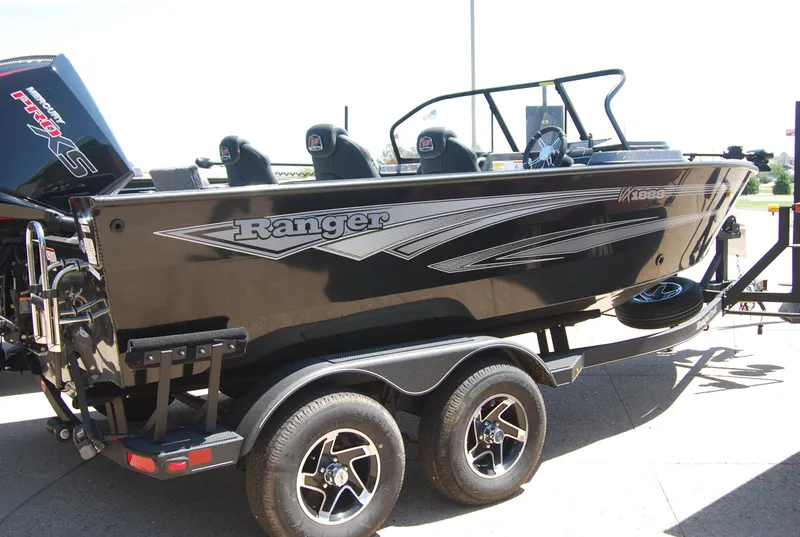 Slide: The Image of 2024 Ranger VX1888 WT boat on trailer, sleek black design, dual axles, outdoor setting. - 0