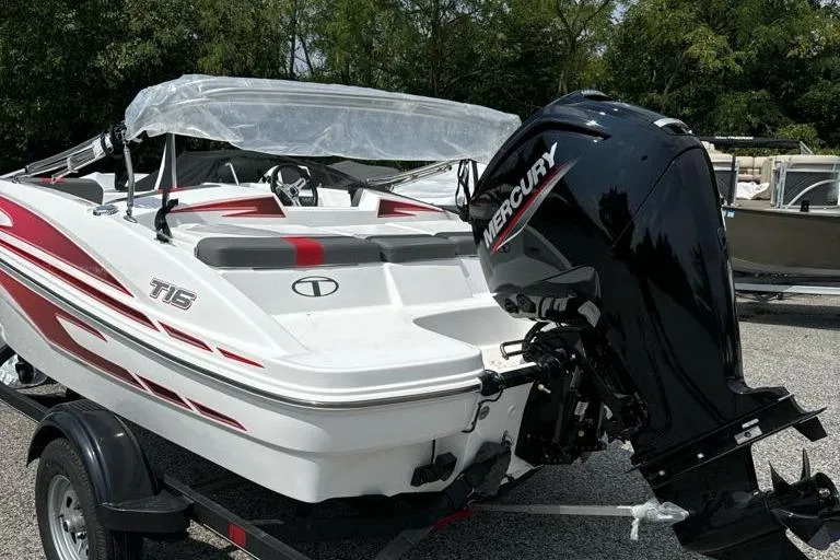 Slide: The Image of 2024 Tahoe T16 boat with Mercury engine on trailer, featuring red and white design. - 1