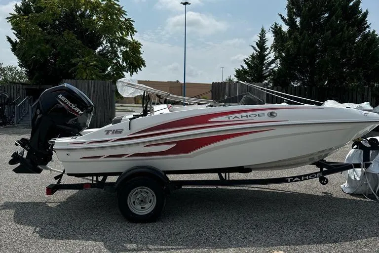 Slide: The Image of 2024 Tahoe T16 boat on trailer, white with red accents, parked outdoors. - 3