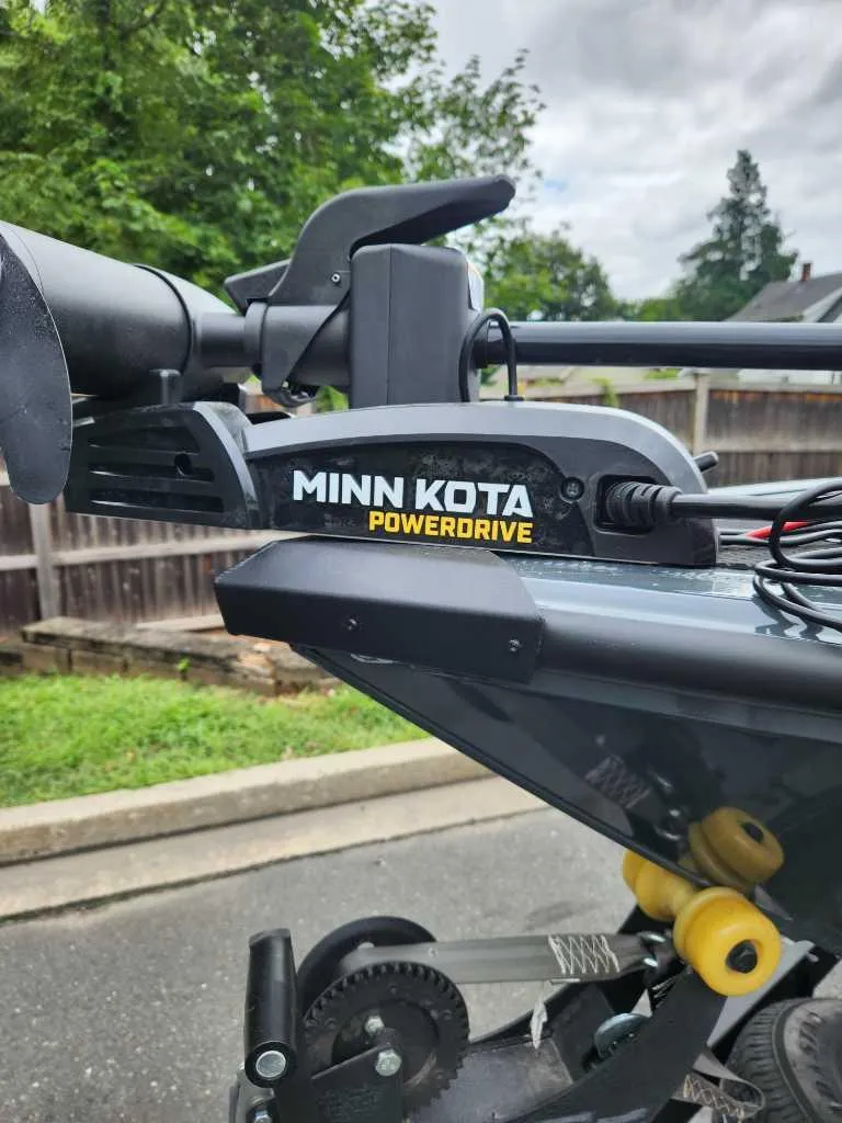 Slide: The Image of 2024 Ranger VS1682SC Angler with Minn Kota PowerDrive motor in a driveway setting. - 2