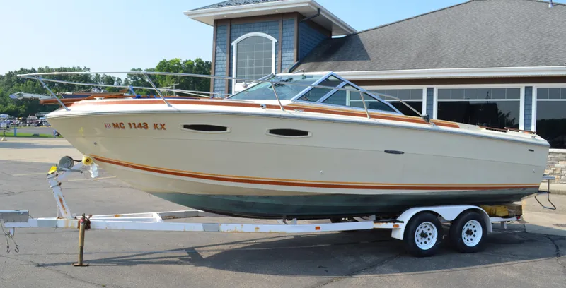 Slide: The Image of 1981 Sea Ray V240 boat on trailer in front of building. - 0